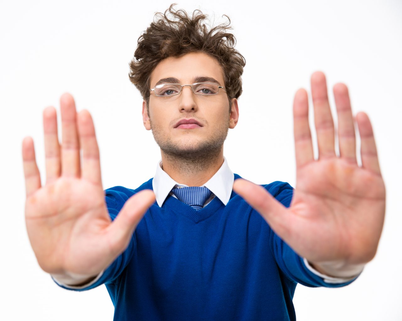 Confident business man showing stop gesture over white background